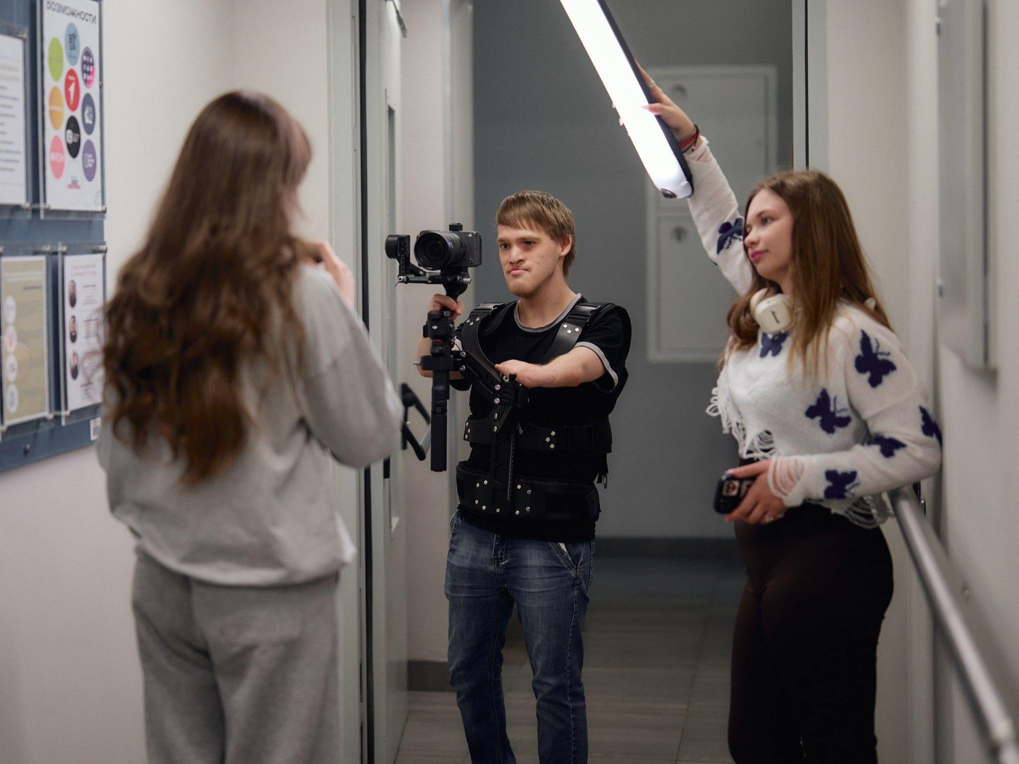 Photo pop-up. Le cliché capture un opérateur de service média en plein travail. L'opérateur est équipé d'un harnais spécial qui permet de stabiliser la caméra et de libérer une main pour travailler.