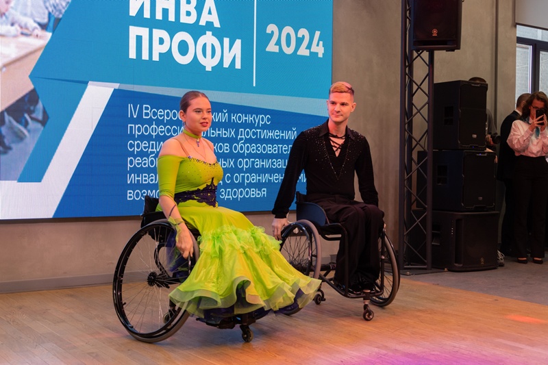 Пара танцоров на спортивных колясках в сценических костюмах выступает на конкурсе «ИНВА ПРОФИ 2024»