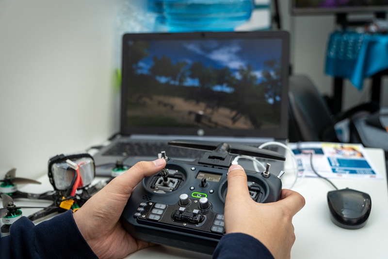 Управление дроном с пульта. Руки пилота и пульт FPV-дрона на рабочем столе